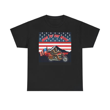 This tee has bigfoot riding on a motorcycle with an American flag hanging off the back. he's riding in front of a mountain that's in front of a patriotic background of stars and stripes. This tee is black